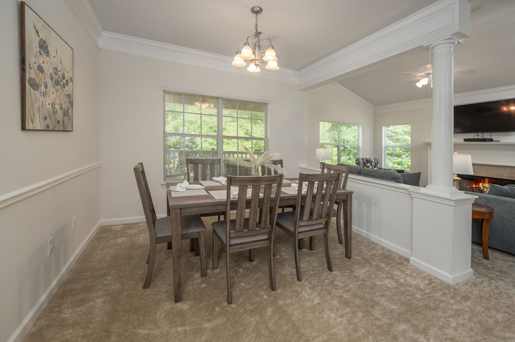 A dining room with a table and chairs.