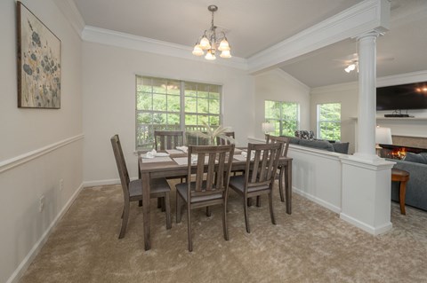 A dining room with a table and chairs.