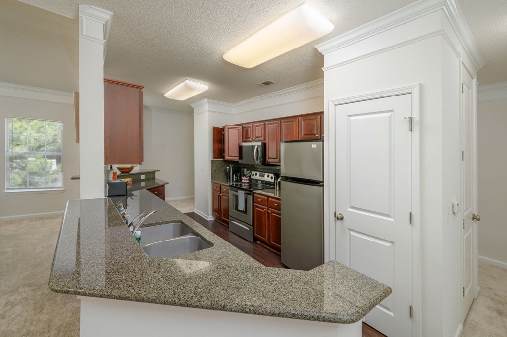 A kitchen with brown cabinets and a granite countertop.