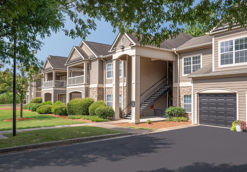 A large, two-story house with a garage and a driveway.