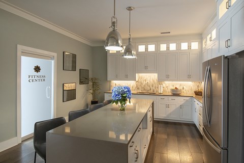 a kitchen with white cabinets and stainless steel appliances and a large island with flowers