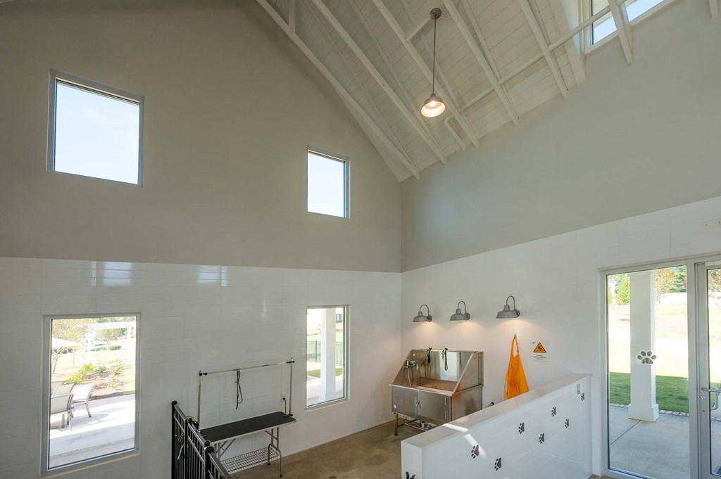 A room with a white ceiling and walls, a window, a table, and a bench.