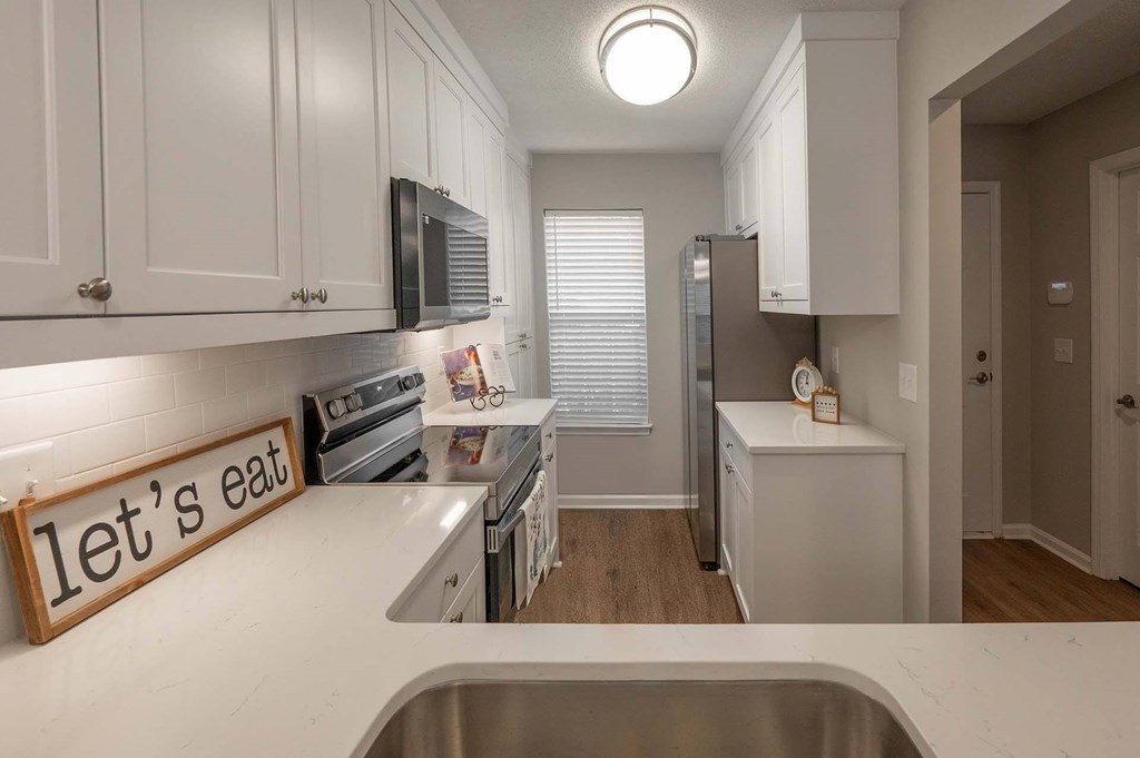 A kitchen with a sign that says "let's eat" on the counter.