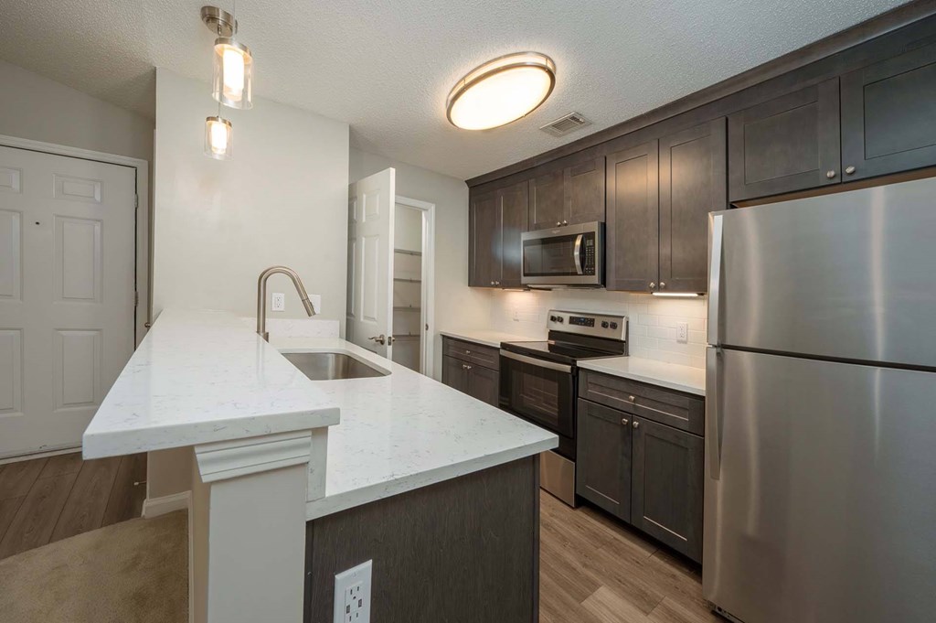 A kitchen with a white countertop and stainless steel appliances.