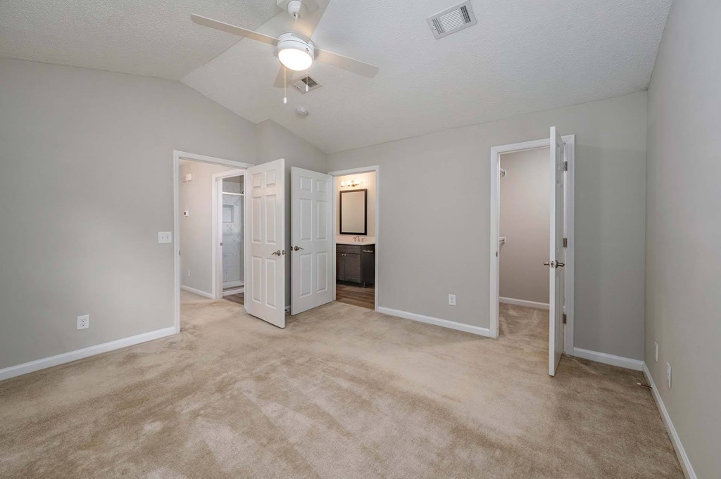 A room with a ceiling fan and carpeted floor.