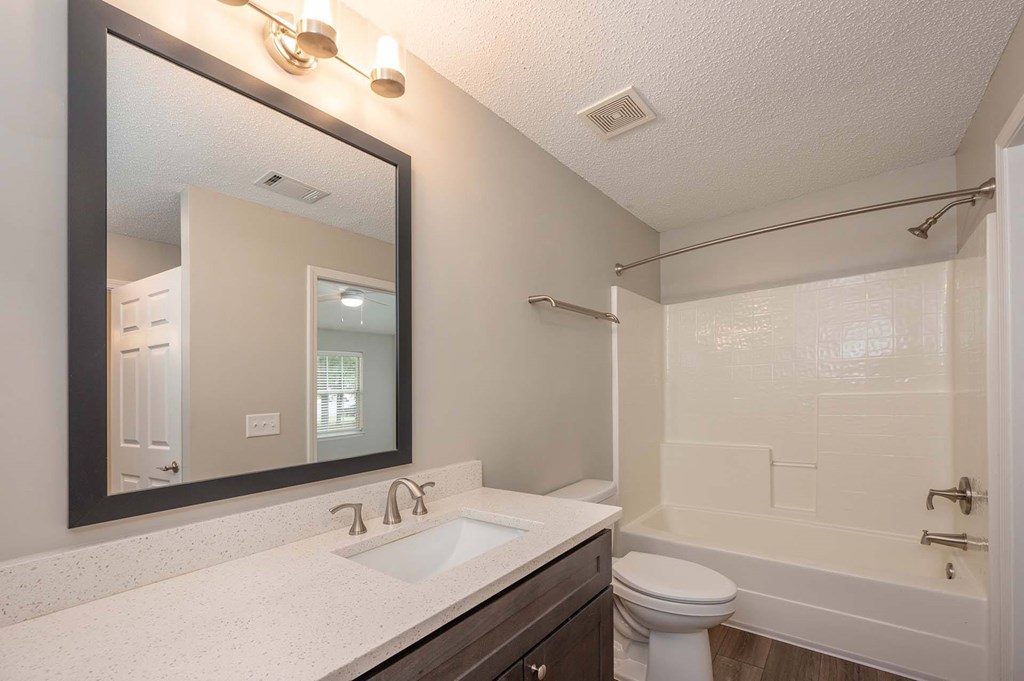 A bathroom with a white sink and a white toilet.