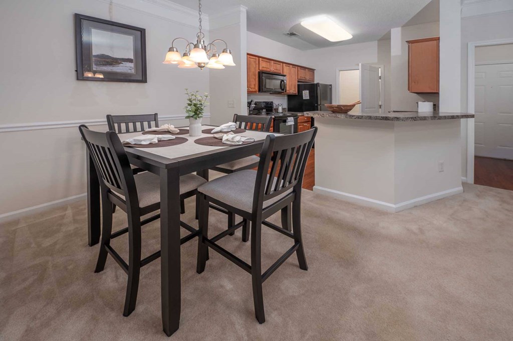 A dining room with a table set for four.
