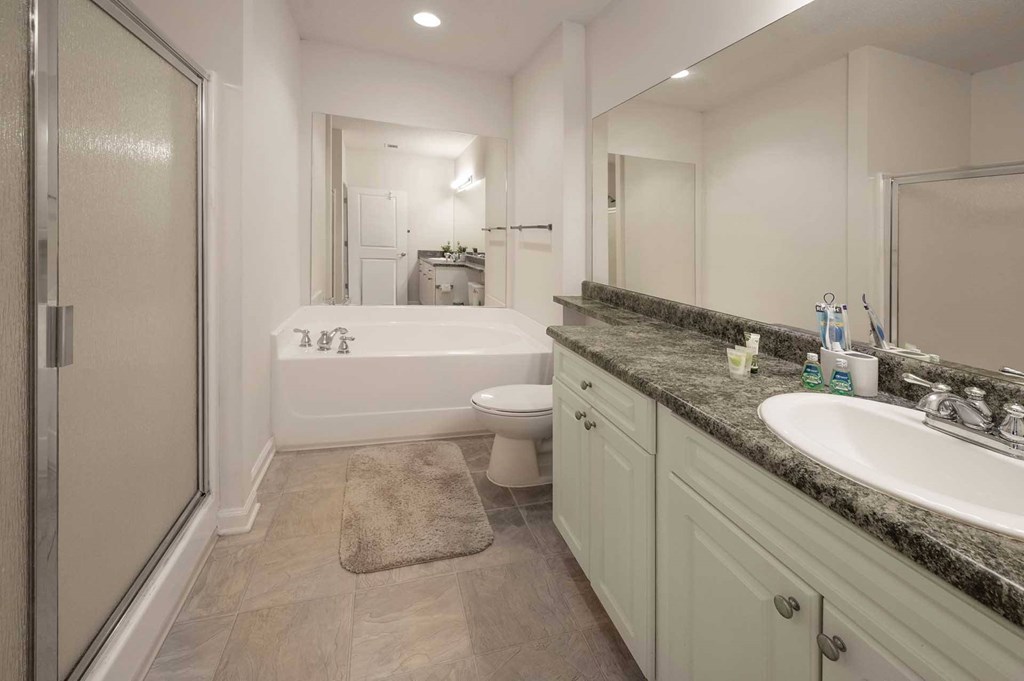 A bathroom with a tub, toilet, and sink.