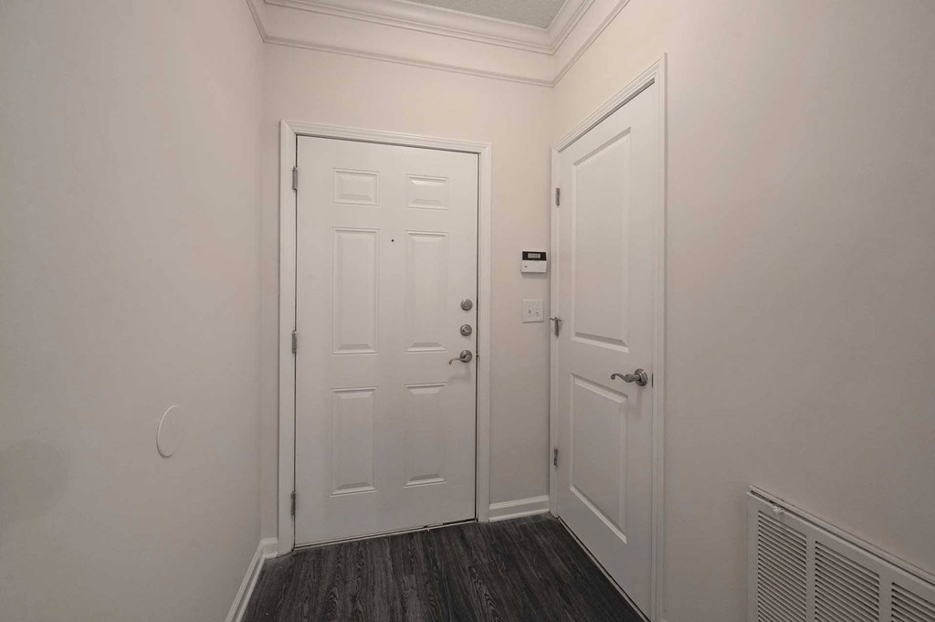A white door is closed and a smaller white door is open.