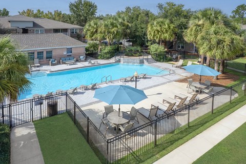 A pool surrounded by chairs and umbrellas.