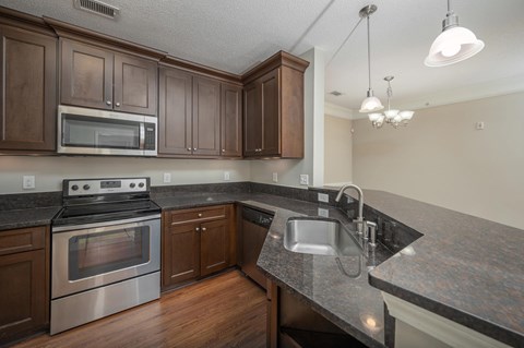 A kitchen with a stove top oven, microwave, and sink.