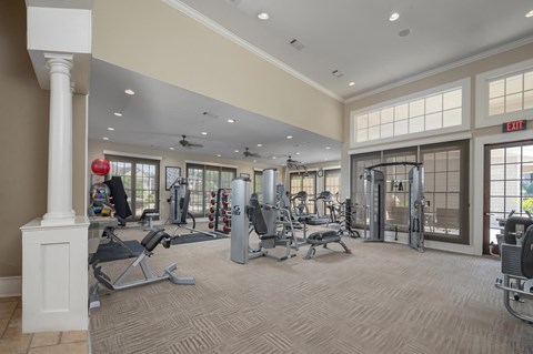 A gym with a variety of equipment including treadmills, weights, and exercise machines.