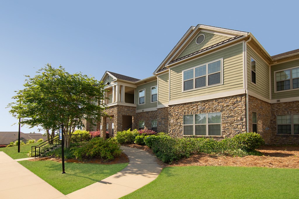 a view of the exterior of a building with a sidewalk and grass