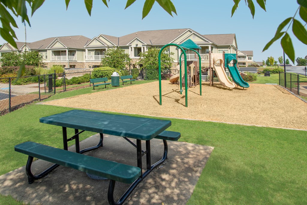 a playground with a slide and picnic table in a park