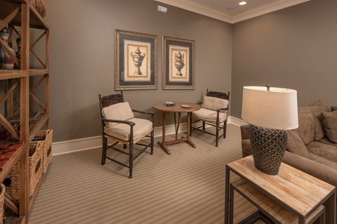 A living room with a wooden coffee table and two chairs.