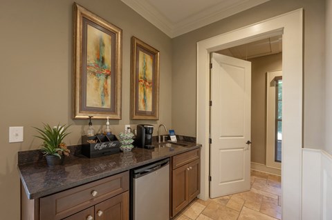 A kitchen with brown cabinets and a black counter top.