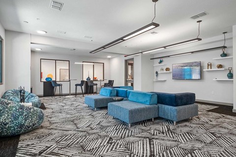 A modern living room with a large blue sofa and a patterned carpet.