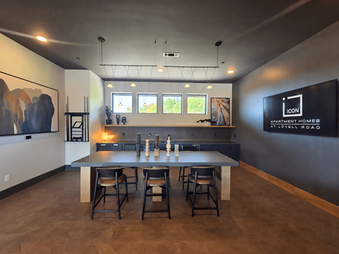 A modern kitchen with a bar area and a dining table.