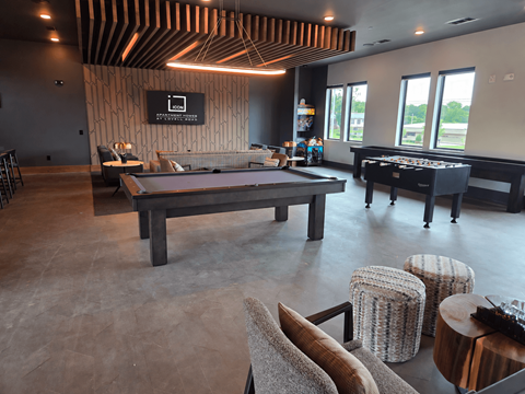 A room with a pool table and a bar.