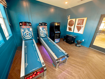 A room with a bowling alley setup and two bowling pins.