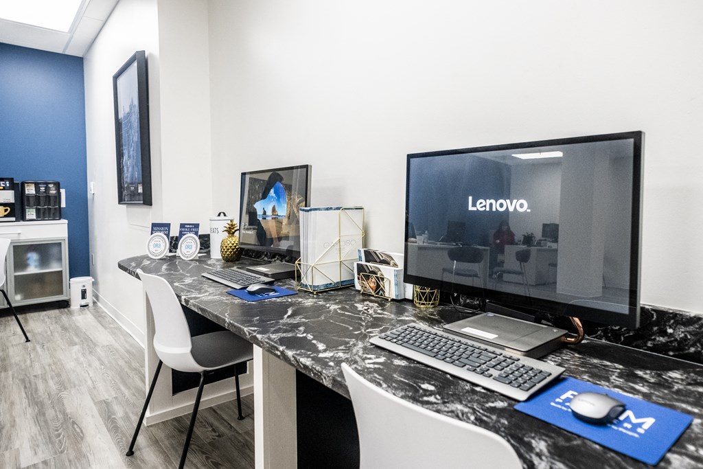 an office with a computer and a desk with a keyboard and mouse