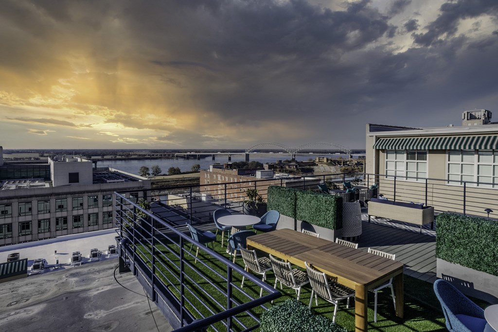 a rooftop terrace with tables and chairs and a view of the city and a