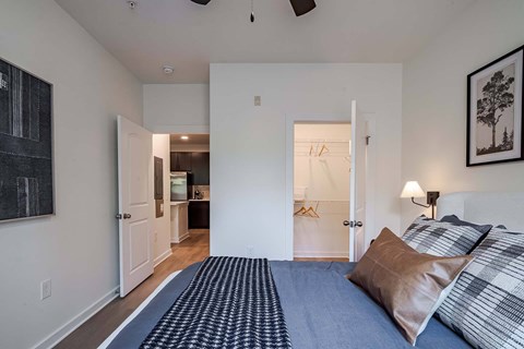 A bedroom with a bed and a painting on the wall.