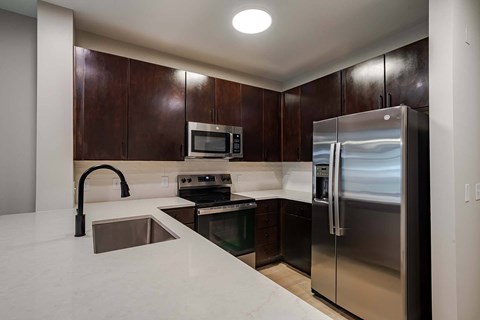 A kitchen with a stainless steel refrigerator and microwave.
