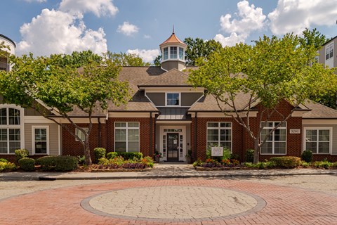 A building with a brick facade and a circular brick walkway in front.
