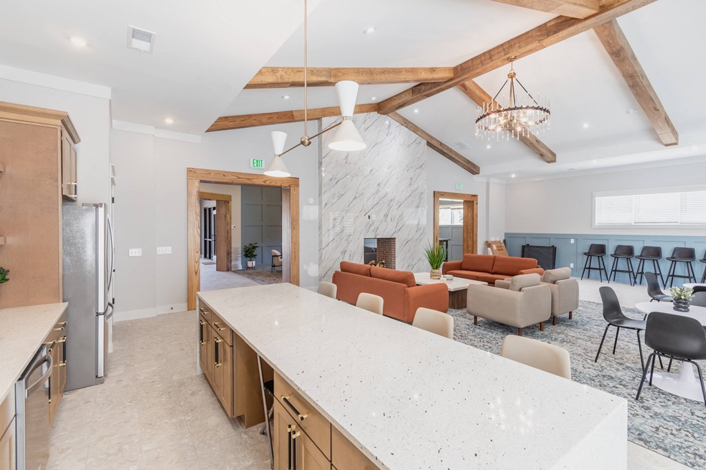a kitchen with a large island and a living room with couches