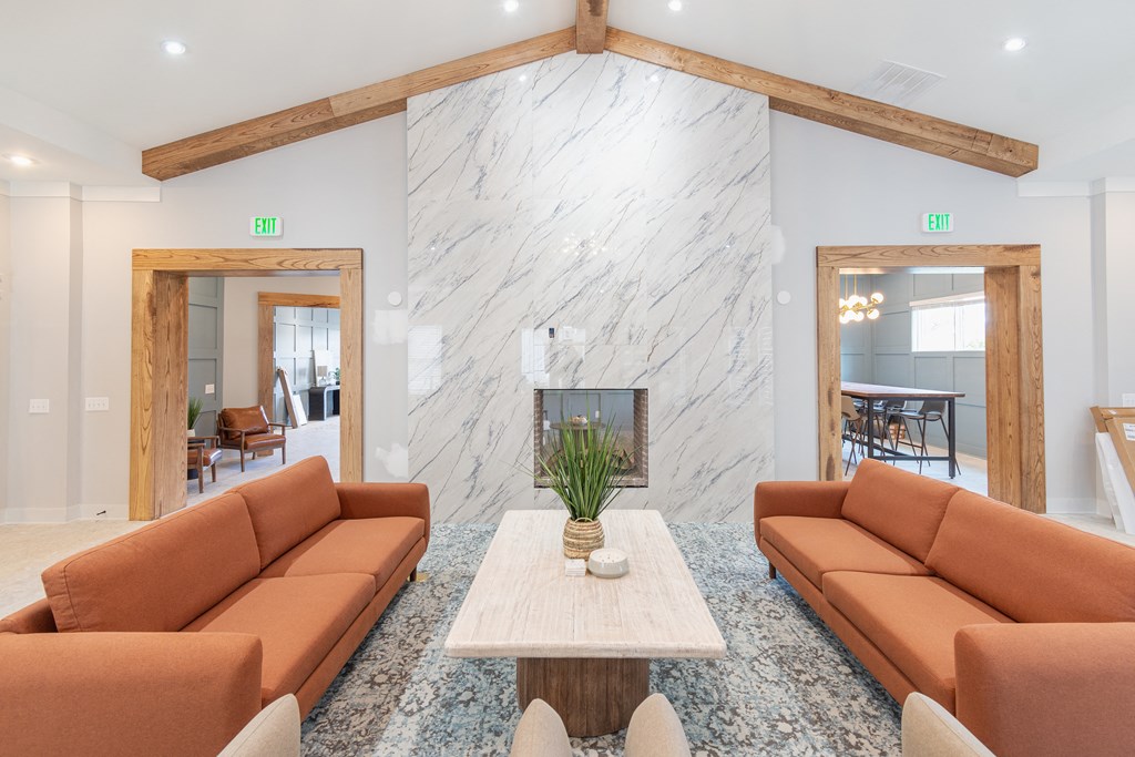 a living room with brown couches and a marble fireplace