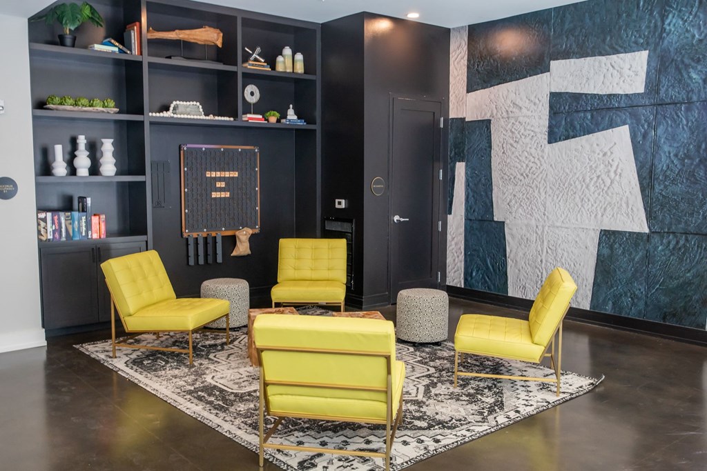 A living room with a black bookshelf and yellow chairs.