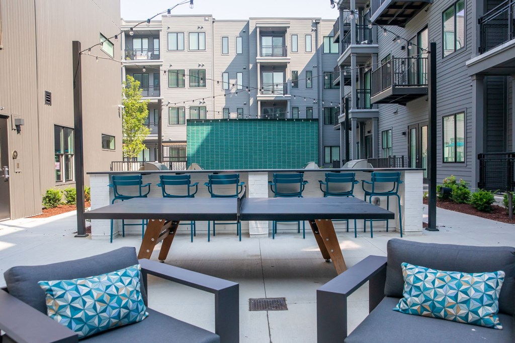 A patio with a table and chairs with a blue cushion.