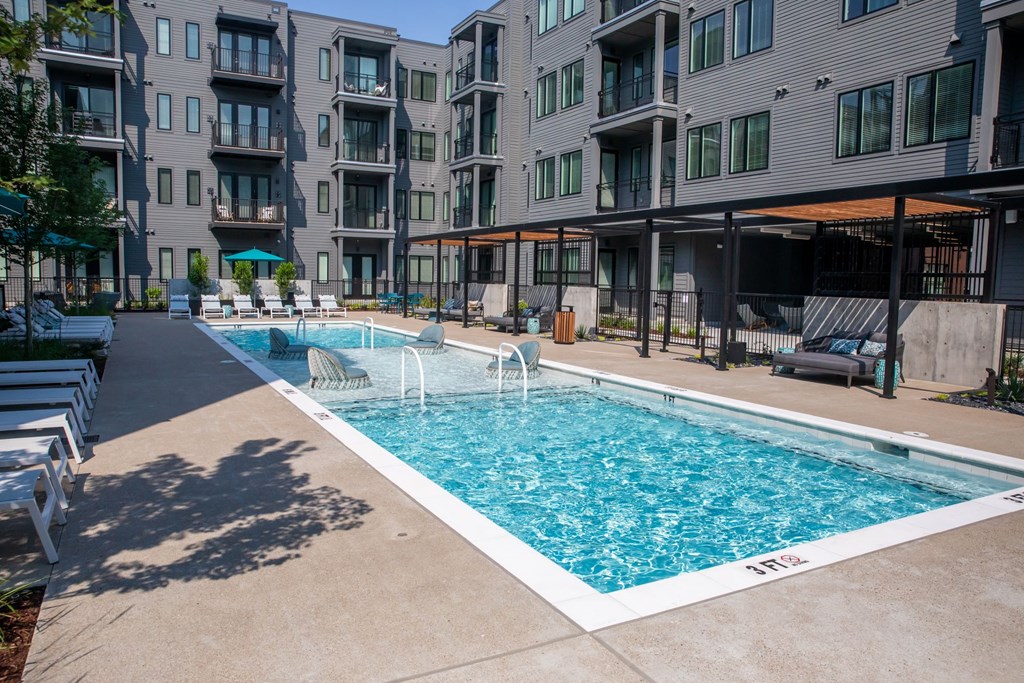 A swimming pool in front of apartment buildings.