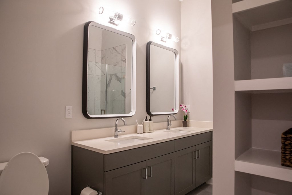 A bathroom with a white sink and a large mirror above it.