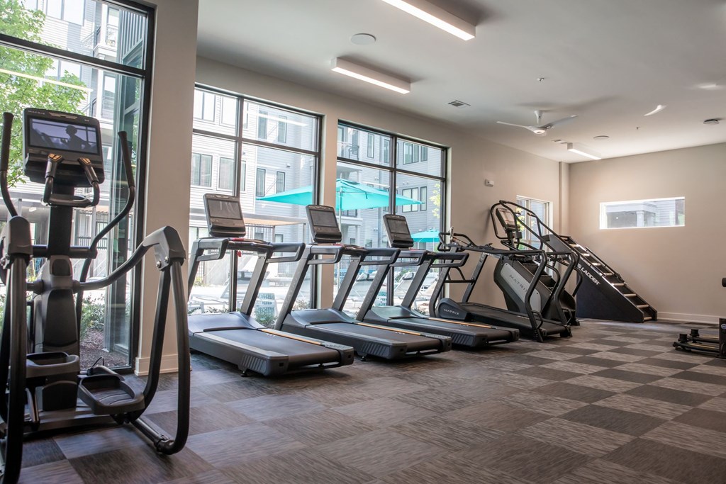 A gym with treadmills, elliptical machines, and a stair climber.