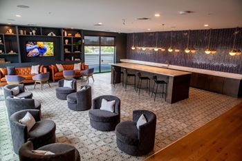 A modern lounge area with grey and orange seating.