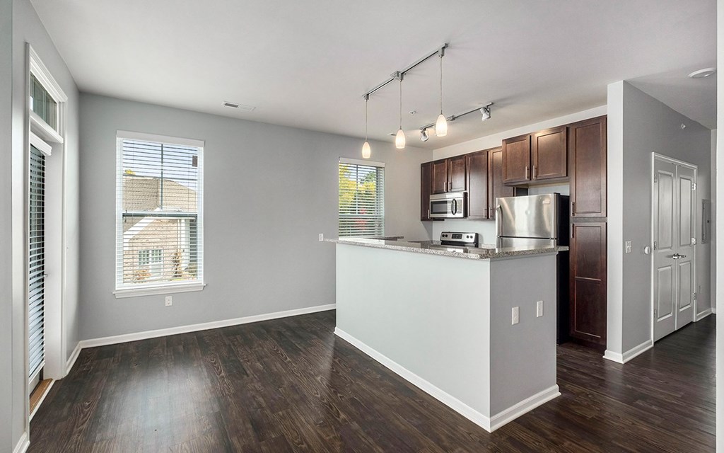 A kitchen with a white counter and brown cabinets.