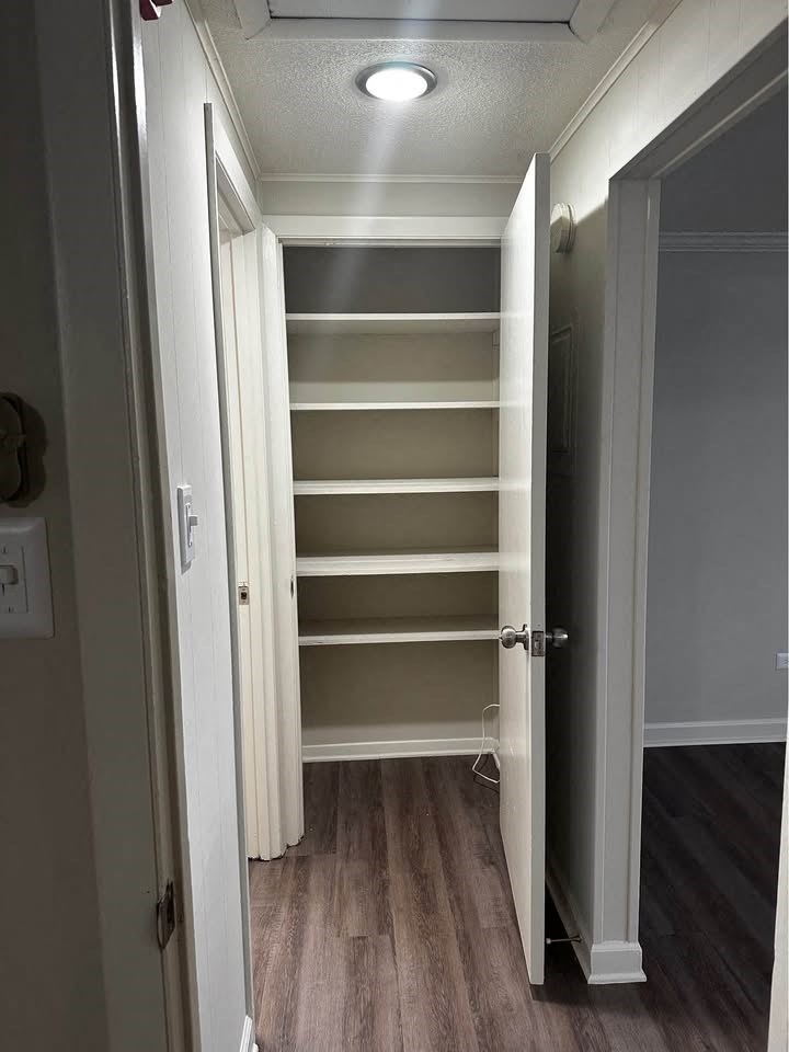 A white door is open to a hallway with a light on the ceiling.