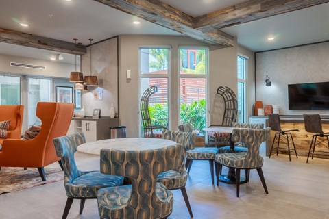 A living room with a round table surrounded by chairs.
