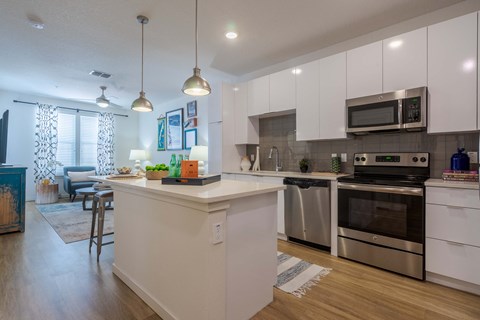 A modern kitchen with white cabinets and stainless steel appliances.