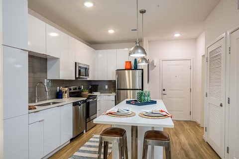 A modern kitchen with a dining table set for two.
