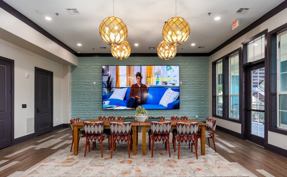 a dining room with a table and chairs and a tv on the wall