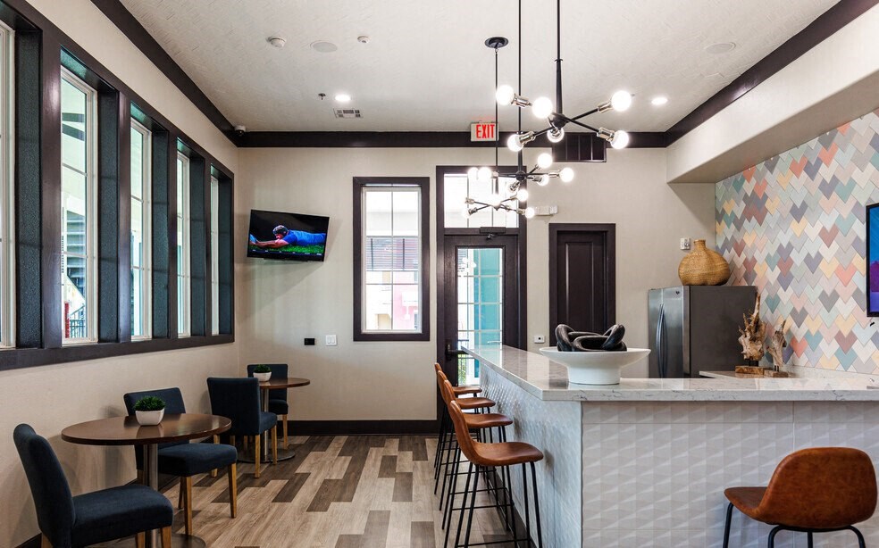 a lobby with a counter and chairs and a tv