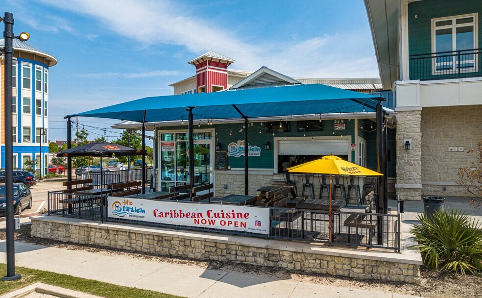 the outside of a restaurant with tables and umbrellas