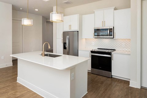 a white kitchen with stainless steel appliances and white cabinets