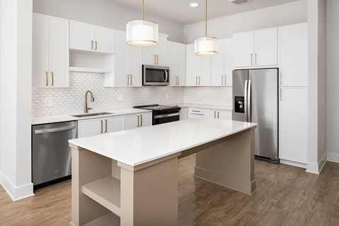 a white kitchen with stainless steel appliances and white cabinets