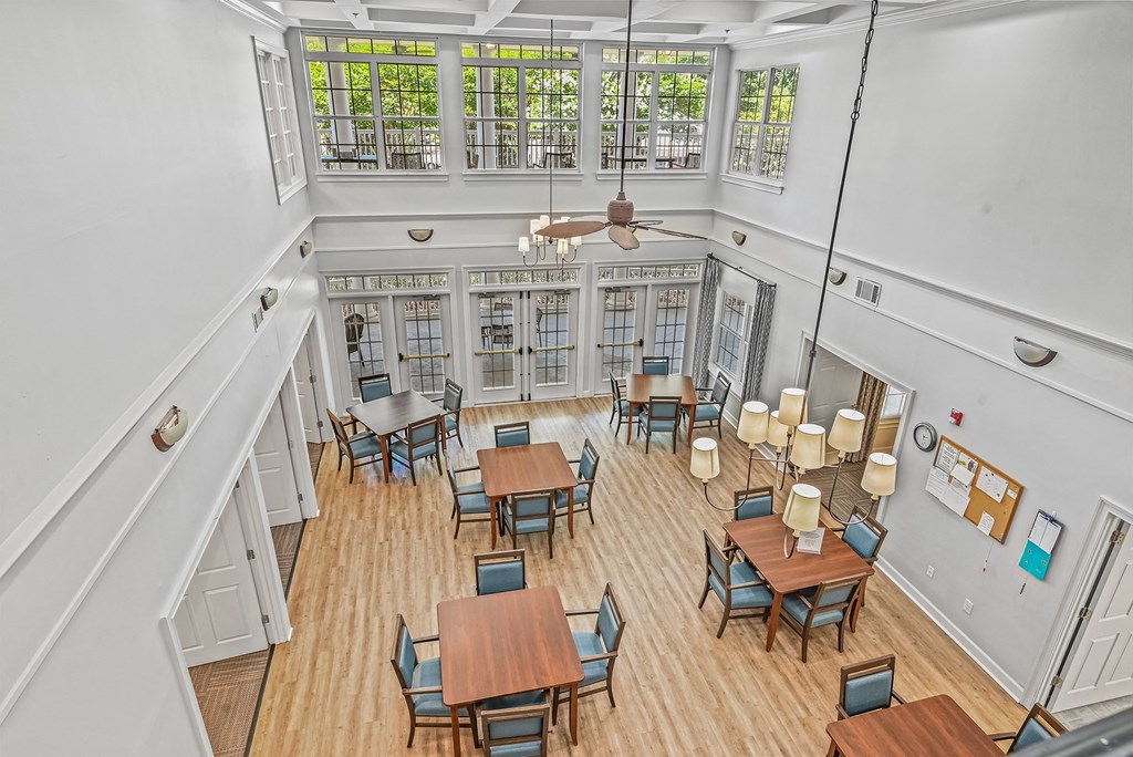 a large room with tables and chairs and a ceiling fan