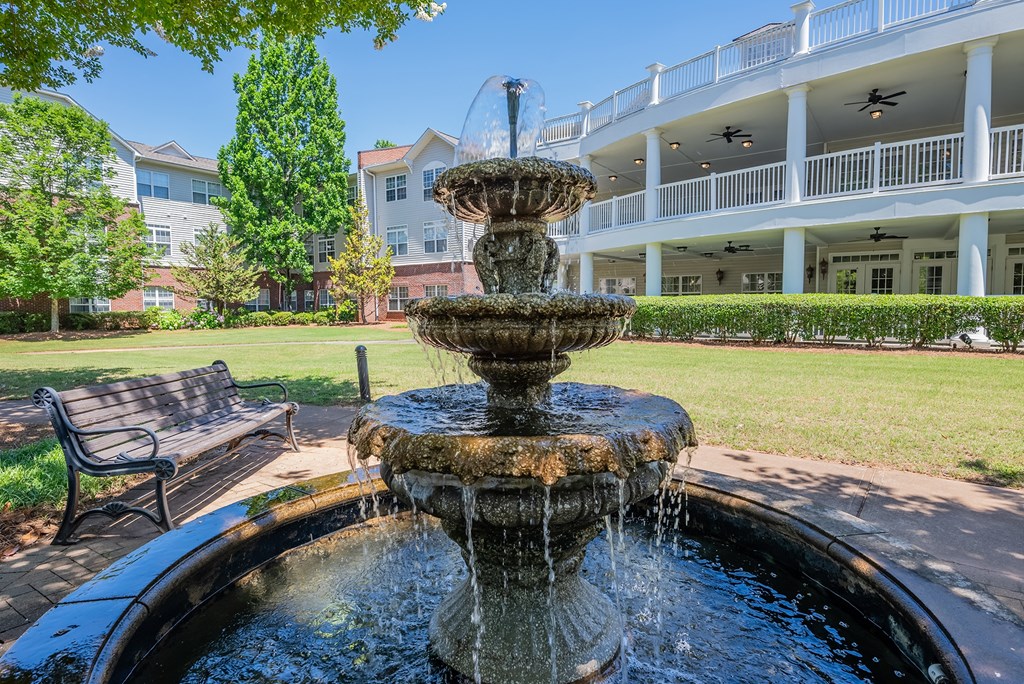 a fountain in a park with a building in the background