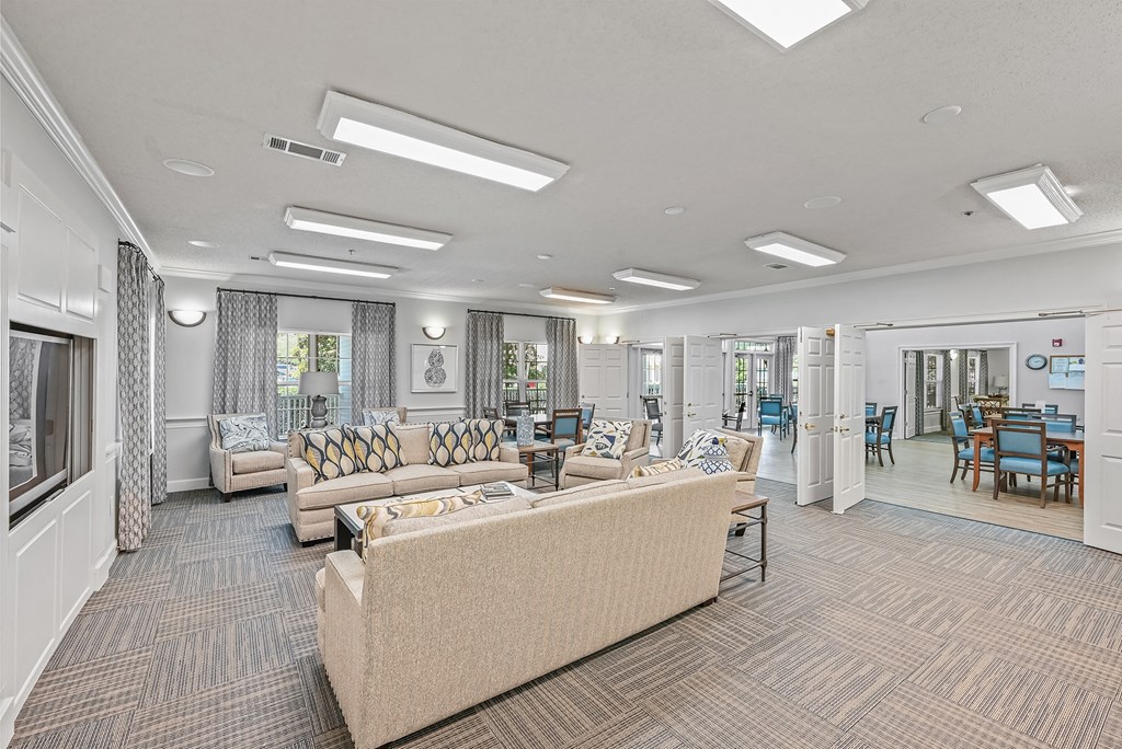 a community room with couches and chairs and a table with chairs